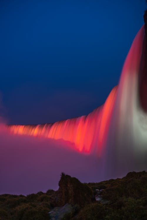 Fotografía vertical de las cataratas iluminadas por la noche
